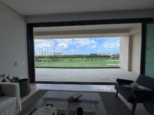 Departamento premium en venta en La Vela Puerto Cancún con terraza y vista al campo de golf y al mar Caribe