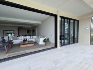 Sala y comedor con ventanales y vista al mar en departamento exclusivo en La Vela Puerto Cancún