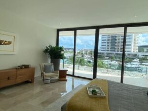Dormitorio moderno con ventanales de piso a techo en departamento exclusivo en Puerto Cancún Cancún