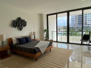 Recámara secundaria luminosa en departamento de lujo en venta en Puerto Cancún con vista exterior