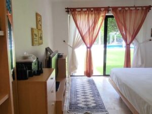 Recámara principal con vista a jardines y alberca en departamento en venta en zona hotelera Cancún con amenidades de primer nivel y áreas verdes