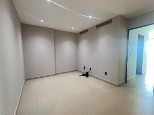 Sala de televisión en departamento de lujo frente al mar en Puerto Cancún con arquitectura moderna y acabados de alta gama